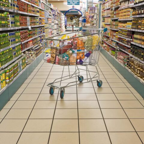 Carrello per la spesa in mezzo al corridoio del supermercato