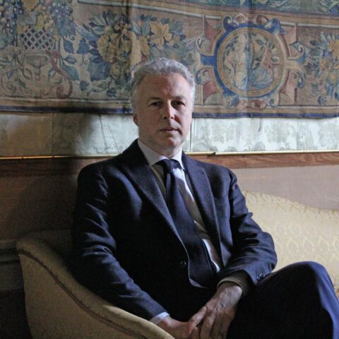 Giacomo di Thiene seduto divano alle spalle un arazzo