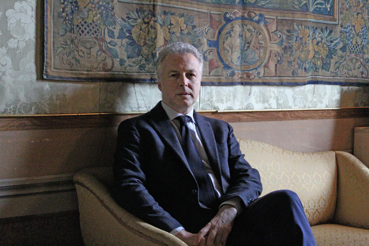 Giacomo di Thiene seduto divano alle spalle un arazzo